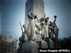 Figures at the base of a statue of Shevchenko in Kharkiv.