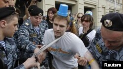 Officers detain a "blue bucket" activist in Moscow on May 2.