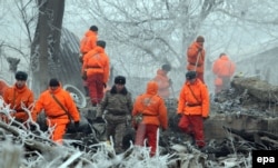 Rescuers sift through the wreckage at the crash site near the Manas airport on January 17. Eyewitnesses say looting broke out almost as soon as police and emergency workers arrived on the scene.