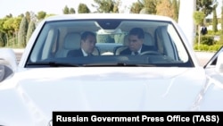 Medvedev and Berdymukhammedov sit inside a Russian-made limousine at the Caspian Economic Forum.