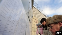 Relatives of demonstrators detained during a mass rally protesting the reelection of President Alyaksandr Lukashenka check a list of prisoners outside a prison in Minsk on December 21.