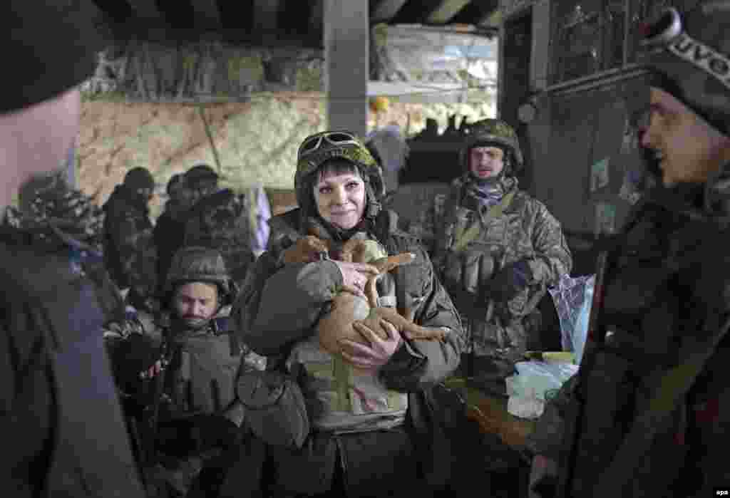 A female Ukrainian soldier holds a dog at a checkpoint in the village of Pesky near Donetsk.