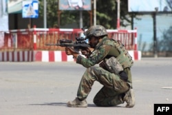 An Afghan National Army commando aims his weapon amid ongoing fighting between Taliban militants and Afghan security forces in Kunduz on October 5.