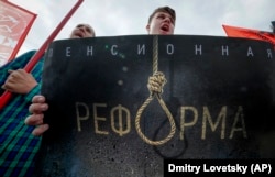 People hold a poster reading "Pension reform" during a Communist Party rally protesting retirement-age hikes in St. Petersburg on September 2.