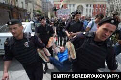 Russian riot police detain LGBT activist Nikolai Alekseyev during an unauthorized rally in central Moscow in May.