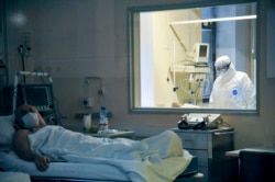 A doctor observes through a glass window the condition of a coronavirus patient in Moscow's Sklifosovsky emergency hospital on March 25.