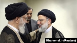 Iranian Supreme Leader Ayatollah Khamenei (left) talks to the country's hard-line President Ebrahim Raisi. (file photo)