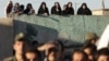 Iranians watch the public execution of a convicted man in the city of Qazvin in May 2011.