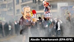 An Iranian man holds a cartoon of Israeli Prime Minister Benjamin Netanyahu during the annual anti-Israeli Al-Quds Day rally in Tehran on June 8.