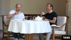 Russian President Vladimir Putin (left) and Prime Minister Dmitry Medvedev drink tea during breakfast at the Bocharov Ruchei state residence in Sochi on August 30.