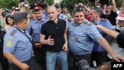 Police officers detain Russian opposition leader Sergei Udaltsov (center) in Moscow on August 9.