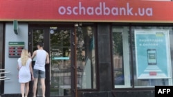 People try to enter a closed branch of Oschadbank in Kyiv on June 27, after many banks were hit by a massive cyberattack.