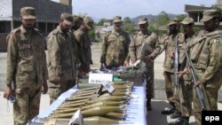 Pakistani Army soldiers show arms and ammunition recovered during operations against Taliban militants 