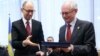 European Council President Herman Van Rompuy (right) exchanges documents with Ukrainian Prime Minister Arseniy Yatsenyuk during the signing of the political provisions of the bloc's Association Agreement with Ukraine in Brussels on March 21.