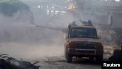 Free Syrian Army fighters fire from the back of a pick-up truck in the Ramous area, southwest of Aleppo, on August 2.