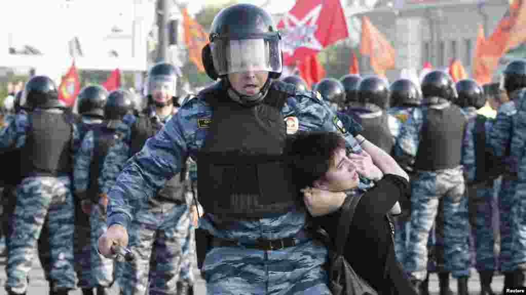 Riot police detain a protester.