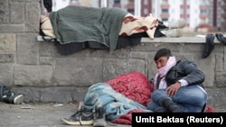 Afghan migrants rest outside a bus terminal as they struggle to find buses to take them to western Turkish cities after crossing the Turkey-Iran border in Agri, eastern Turkey, on April 11.