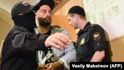 Russian theater and film director Kirill Serebrennikov is escorted by security officers ahead of his hearing at Moscow's Basmanny district court on August 23.