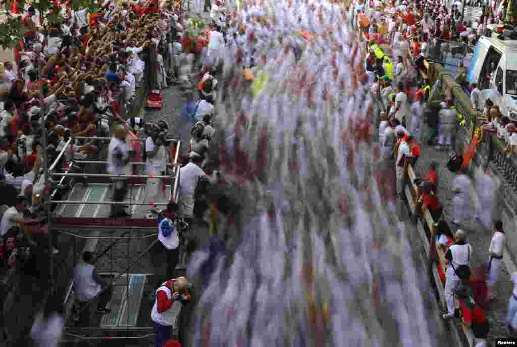 A crowd of runners sprint toward the entrance to the bull ring during the second running of the bulls at the San Fermin festival in Pamplona, Spain. (Reuters/Eloy Alonso)