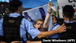 Protesters shout antigovernment slogans during a protest in front of the government headquarters in Bucharest on May 30, after the Constitutional Court ruled for Kovesi's removal.