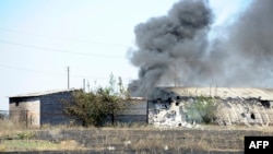 Smoke billows over a damaged building after shelling on the outskirts of the small southern Ukrainian city of Novoazovsk on August 27.