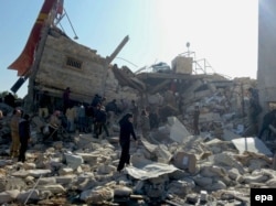 People gather near a destroyed building said to be a Medecins Sans Frontieres (MSF) supported hospital in Marat al Numan, Idlib, Syria, in February 16.