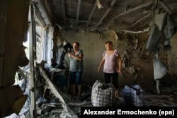 Two women examine their destroyed flat after fighting between Russia-backed separatists and Ukrainian government troops in the town of Yasinovataya in the eastern Donetsk region on August 1.