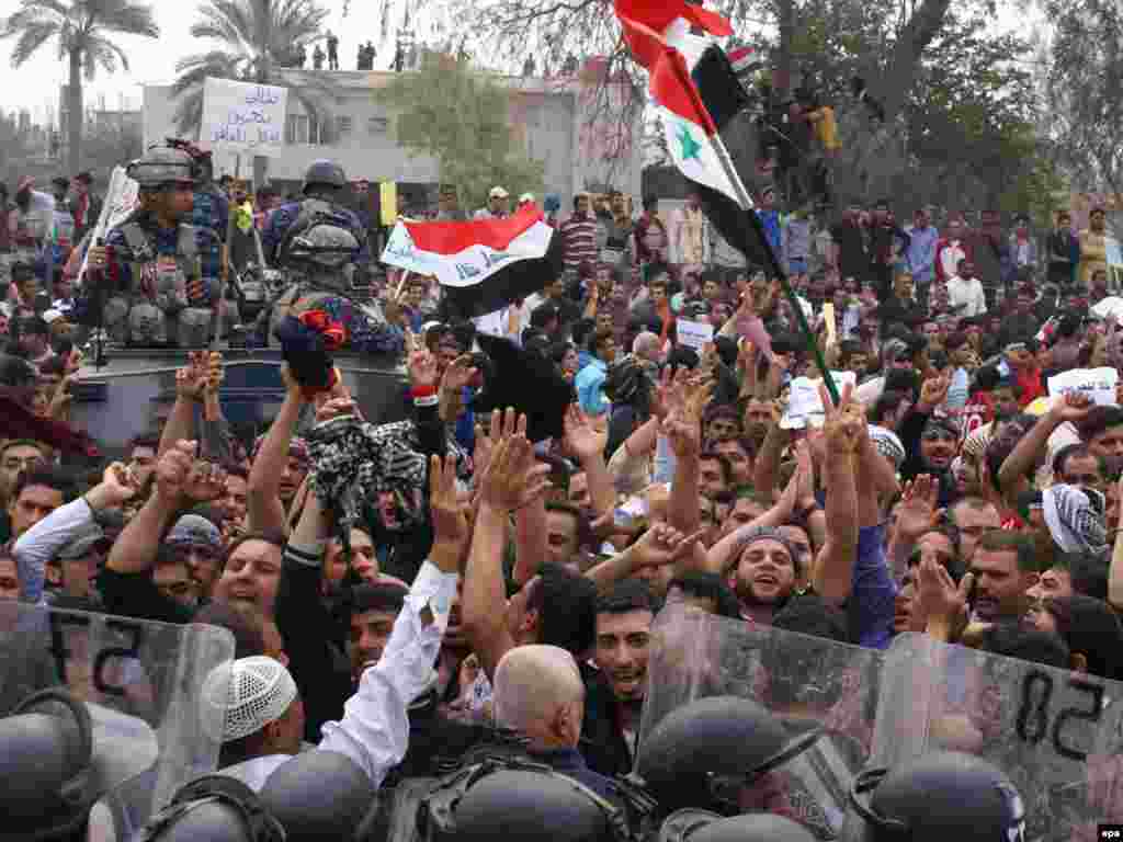 Protesters carry Iraqi national flags during a demonstration in Al-Basrah, in southern Iraq. - 