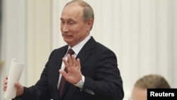 Russian President Vladimir Putin gestures as he arrives for a meeting with G20 summit participants in the Kremlin on February 15.