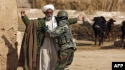 An Afghan soldier frisks a farmer during a patrol northeast of Marjah.