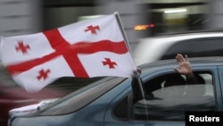 A supporter of presidential candidate Davit Bakradze holds a Georgian national flag at an election rally in Tbilisi on October 24.