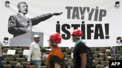 People on Istanbul's Taksim Square pass a banner calling on Prime Minister Recep Tayyip Erdogan to resign. 