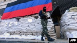 An armed man in military fatigues stands guard outside a regional administration building seized by the separatists in the eastern Ukrainian city of Slovyansk on April 23.