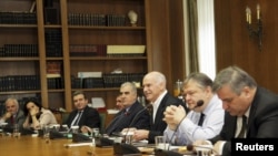 Greek Prime Minister George Papandreou (center), who has agreed to step down, holds an emergency cabinet meeting at the parliament in Athens on November 8.