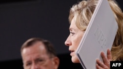 U.S. Secretary of State Hillary Clinton holds up a copy of the Nuclear Posture Review during a news conference with Chairman of the Joint Chiefs of Staff Mike Mullen 