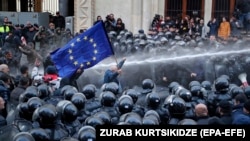 Riot police disperse opposition supporters during a protest rally in front of the parliament building in Tbilisi on November 18. 