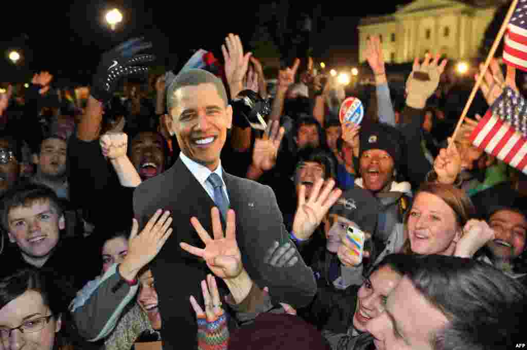 People celebrate in front of the White House in Washington after television networks announced the reelection of U.S. President Barack Obama.