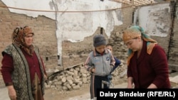 Umida (right) washes rice in a makeshift sink in October 2010 on the site of her former home, which was burned down during ethnic clashes in June 2010 in the southern Kyrgyz city of Osh.