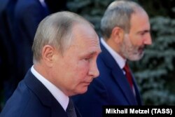 Russian President Vladimir Putin (left) and Armenian Prime Minister Nikol Pashinian. Putin has said a cease-fire must be agreed upon “quickly,” even if a resolution to the decades-old conflict takes longer. (file photo)