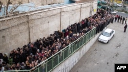 Iranians line up to receive food supplies in southern Tehran. Three people reportedly died while waiting in line in freezing temperatures, and hard-liners have alleged that the sight of citizens lining up for handouts is damaging to Iran's image abroad.