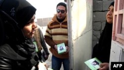 A female candidate from the National list, Zainab Sadiq Jaffer (left), campaigns in Al-Basrah.