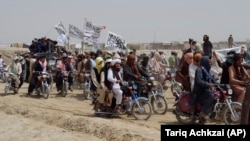 Pakistani supporters of the Taliban fly the Islamist group's signature white flags in the Afghan-Pakistan border town of Chaman on July 14.