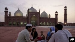 A Pakistani family waits to break their fast in the compound of the Mughal-era Shahi Mosque on August 3.