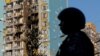 Russian security forces stand guard near a damaged residential area following a Ukrainian attack on the Moscow region.