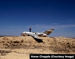 A taxi driver explores the wreckage of a Soviet-era MiG fighter jet in northern Turkmenistan. The plane has been stripped of its most valuable parts.