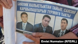 A protester holds a leaflet with pictures of the detained opposition leaders in Osh on October 11.