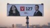 Workers in the Kosovar capital, Pristina, install a giant election poster showing prime ministerial candidate Albin Kurti (right) and acting President Vjosa Osmani. 