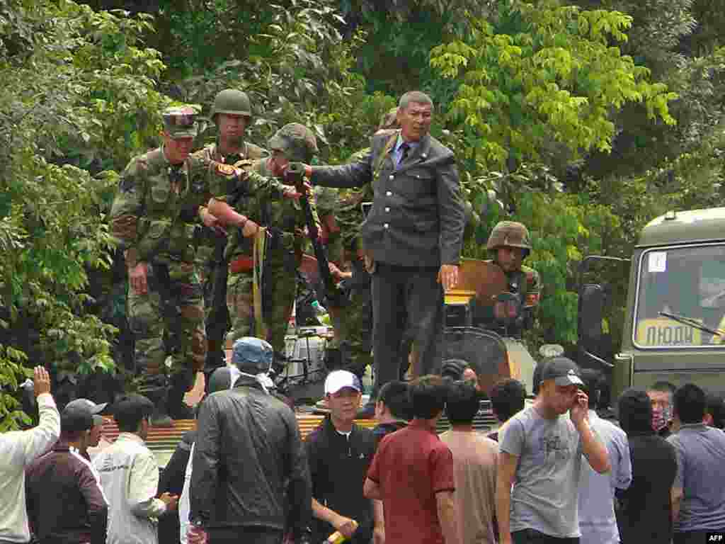 Kyrgyz soldiers stand on an armored vehicle in Osh on June 11.