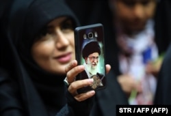 An Iranian woman shows off her phone cover depicting Supreme Leader Ayatollah Ali Khamenei in Tehran. Many warn that the Internet censorship under consideration could widen the gap between Iranians and the clerical establishment.