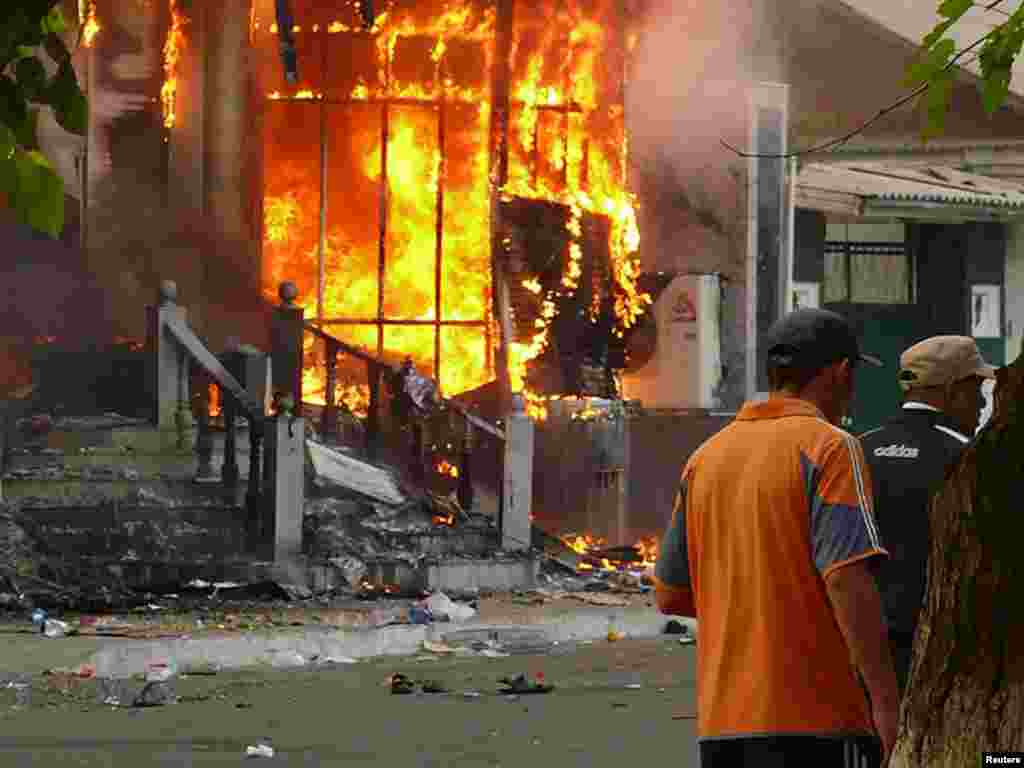 Men walk past a burning building in Osh on June 11, when at least 12 people died in the unrest.